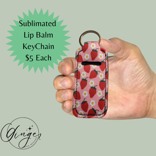 Hand holding a lip balm keychain with strawberry pattern on a light gray background