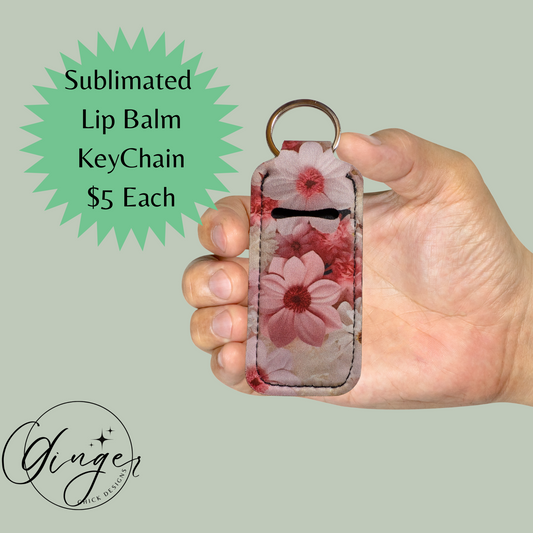 Hand holding a floral sublimated lip balm keychain with promotional text and Ginger Design logo.