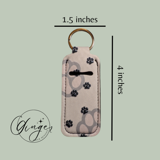 Keychain with paw print design and measurements on a light green background