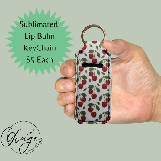 Hand holding a lip balm keychain with cherry design on a light green background