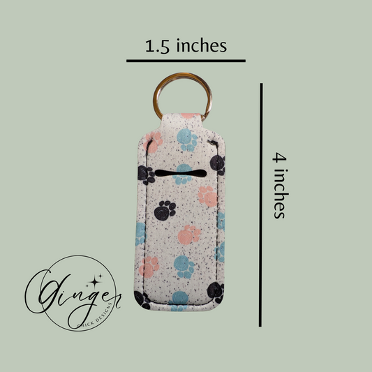 Keychain with paw print pattern and measurements on a light green background