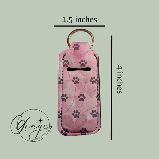 Pink key fob cover with paw prints and measurements on a light green background