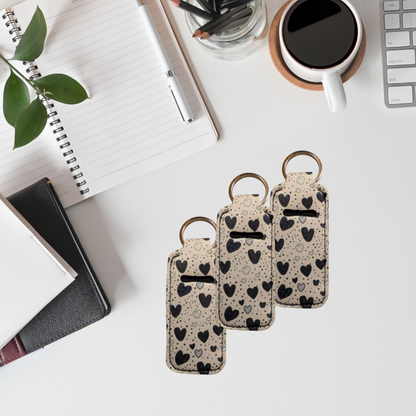 Three keychain card holders with heart pattern on a desk with office supplies.