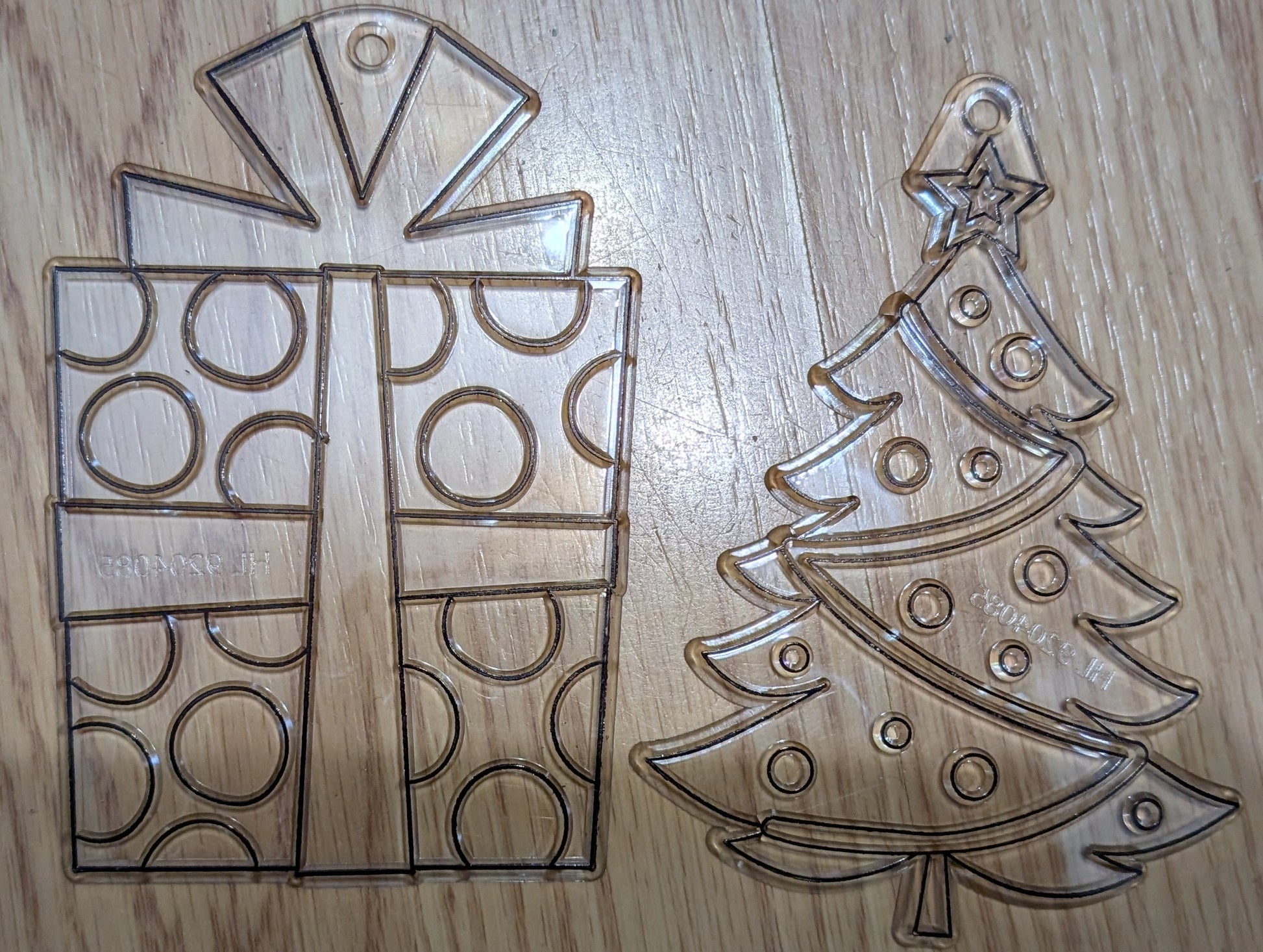 Metallic Christmas tree and gift box cutouts on a wooden surface