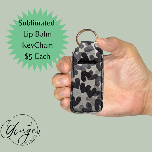 Hand holding a camouflage-patterned lip balm keychain with promotional text on a light green background.