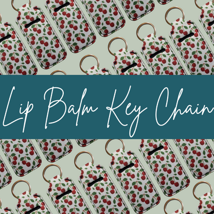 Lip balm key chains with cherry pattern on a light green background