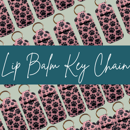 Lip balm key chains with paw pattern on a light green background