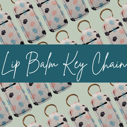 Lip balm key chains with paw print design on a light green background