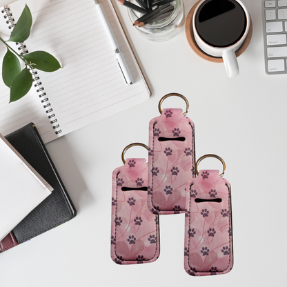 Pink keychain with paw print pattern on a desk with office supplies.