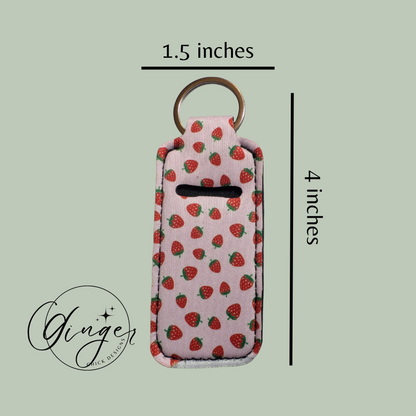 Keychain with strawberry pattern and measurements on a light green background