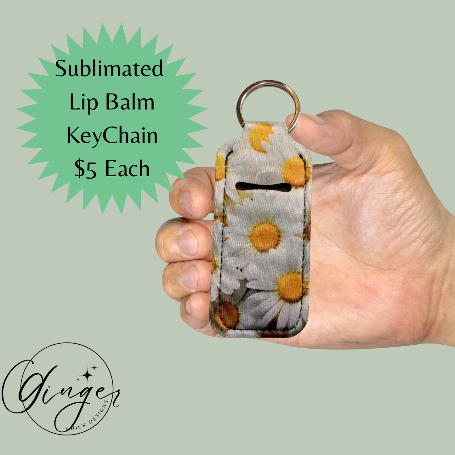 Hand holding a sublimated lip balm keychain with floral design on a light green background