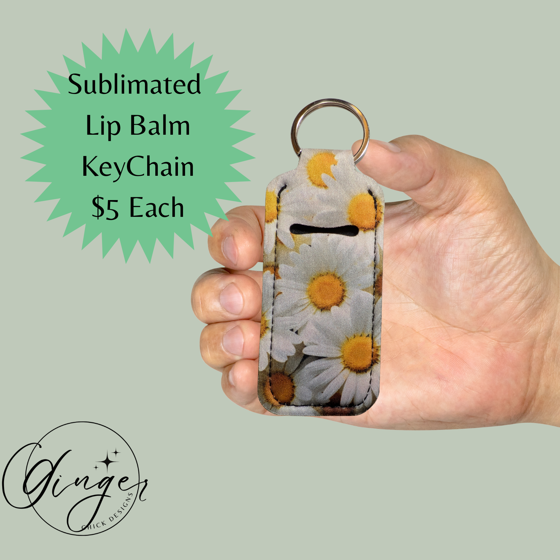 Hand holding a sublimated lip balm keychain with floral design on a light green background